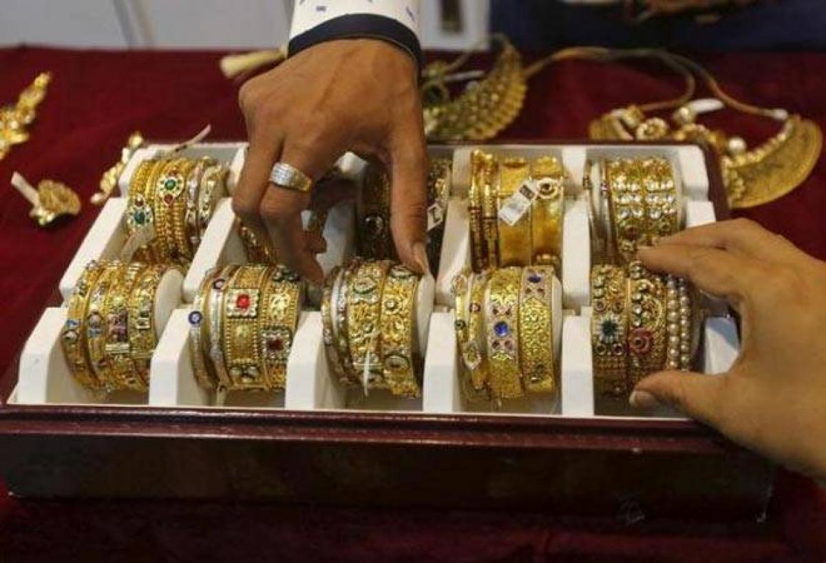 Gold steady on weaker dollar, set for third week of gains